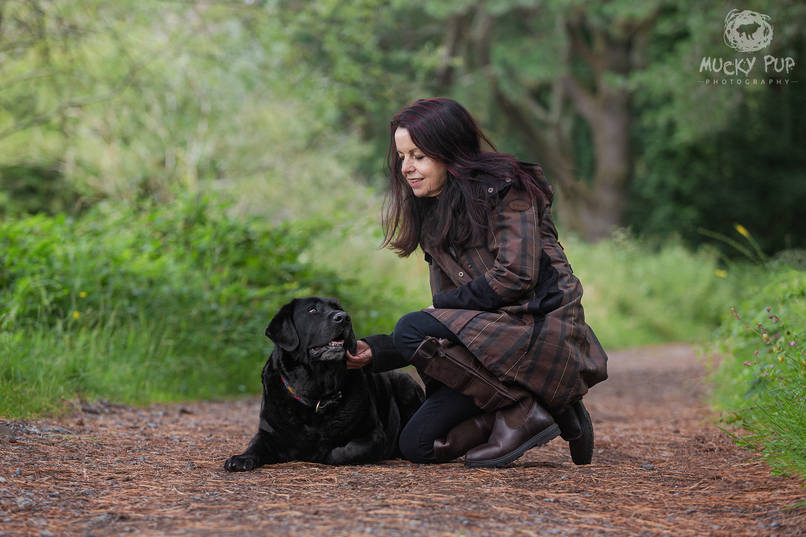 Black lab with his human on a woodland path in Llanmadoc Swansea